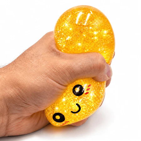 Bolinho dourado com glitter sendo apertado na mão